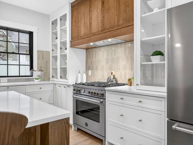 a kitchen with kitchen island granite countertop a sink a counter space appliances and cabinets