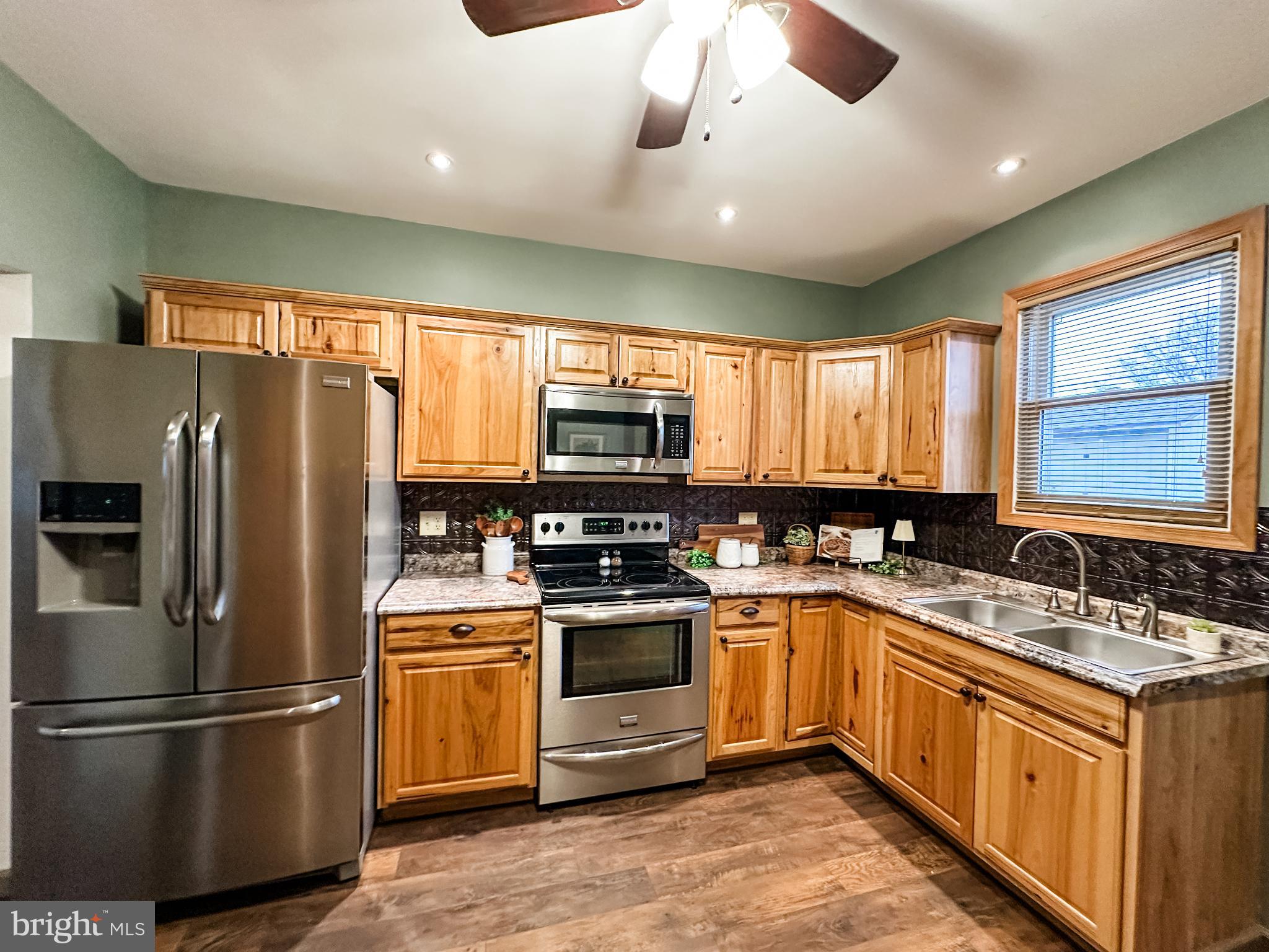 12812 New Row Rd N West Mount Savage, MD 21545 - Photo 15 of 32 a kitchen with stainless steel appliances granite countertop a refrigerator a sink a stove and cabinets