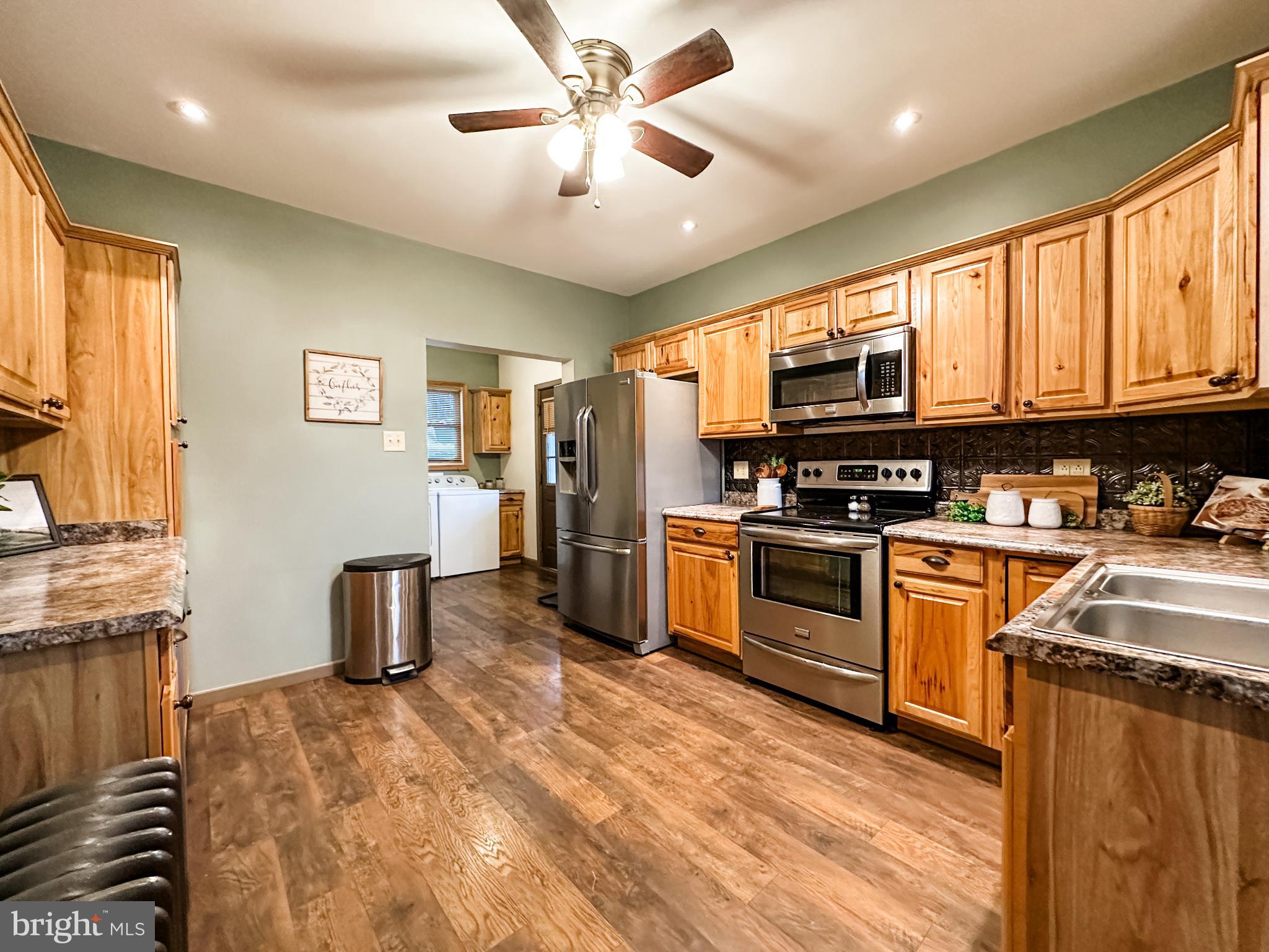 12812 New Row Rd N West Mount Savage, MD 21545 - Photo 16 of 32 a kitchen with stainless steel appliances granite countertop a stove refrigerator and cabinets