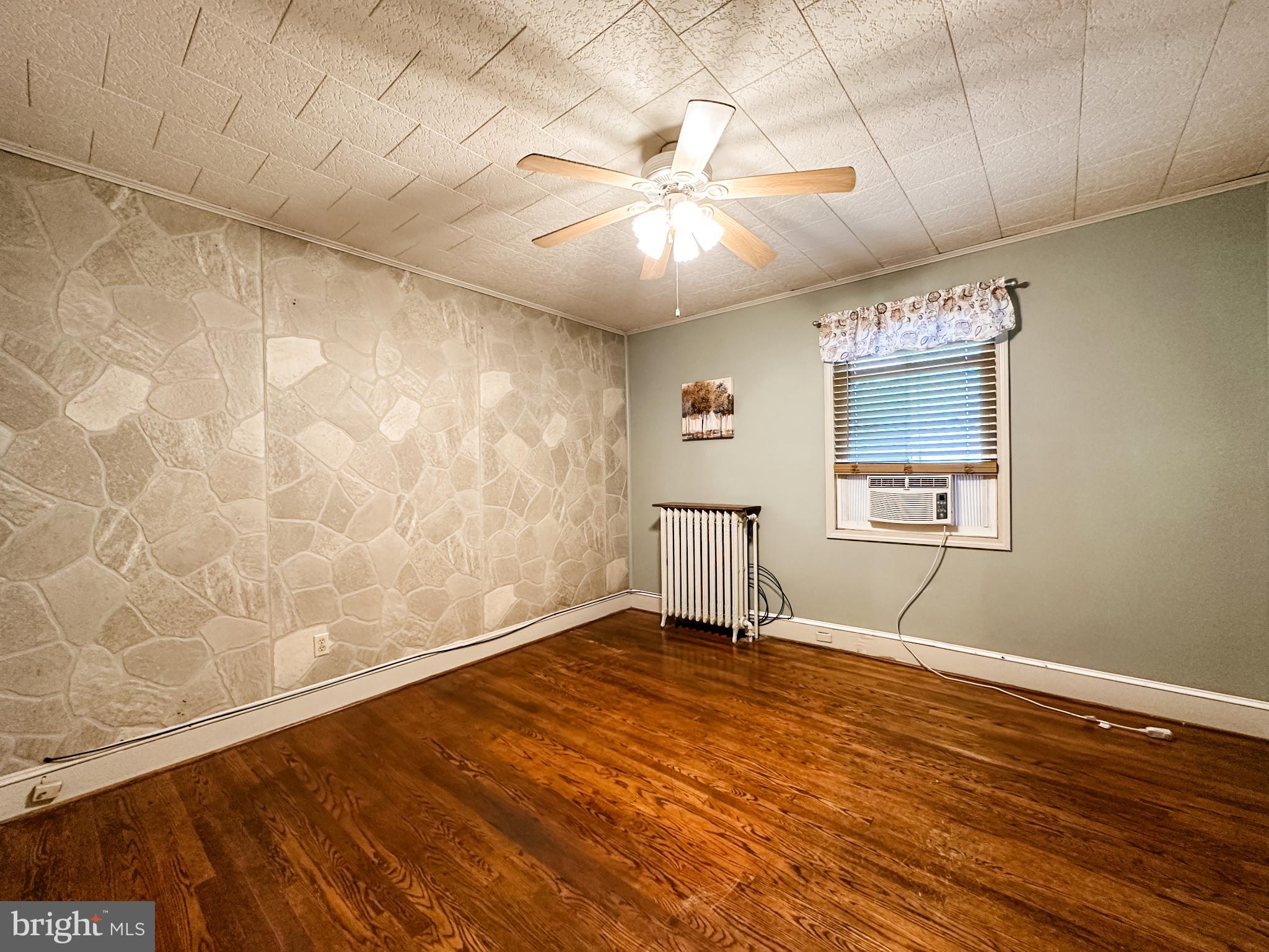 12812 New Row Rd N West Mount Savage, MD 21545 - Photo 25 of 32 an empty room with wooden floor fan and windows