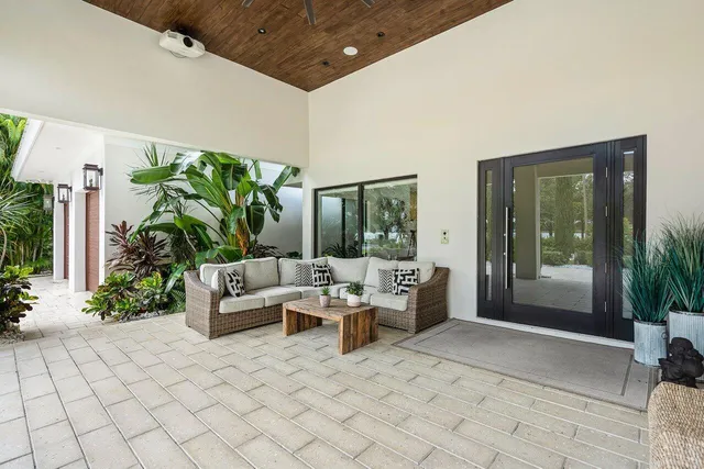 a living room with patio furniture and a potted plant