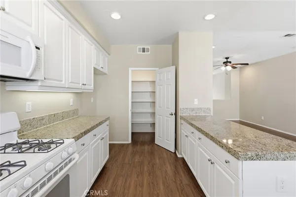 a kitchen with white cabinets and white appliances