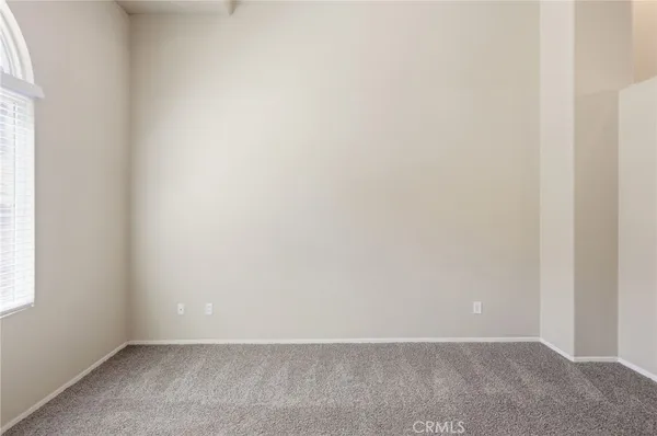 an empty room with a fireplace and windows