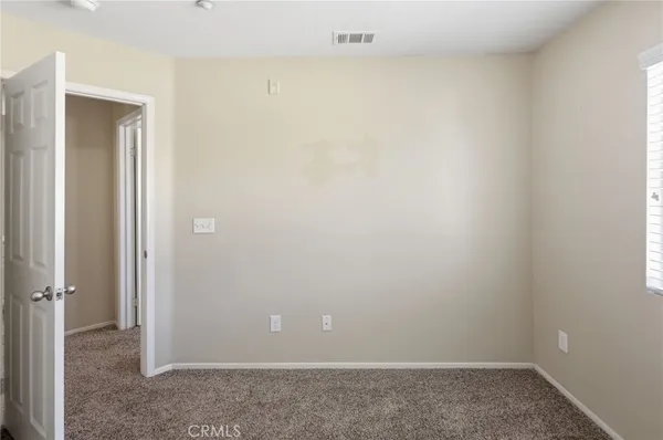 an empty room with closet and a bathroom