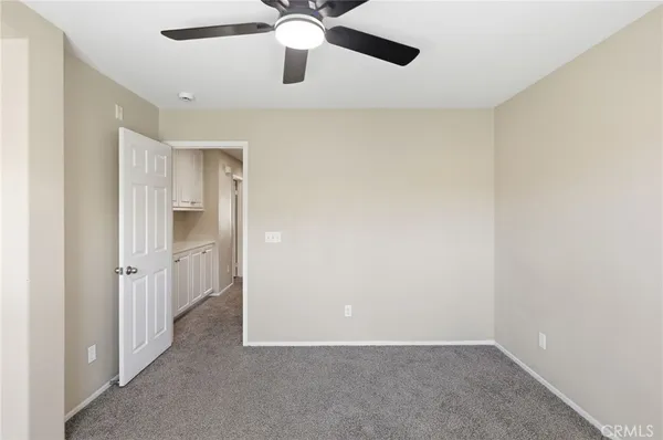 an empty room with a window and a fan