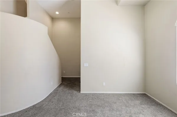 an empty room with wooden floor fireplace and windows