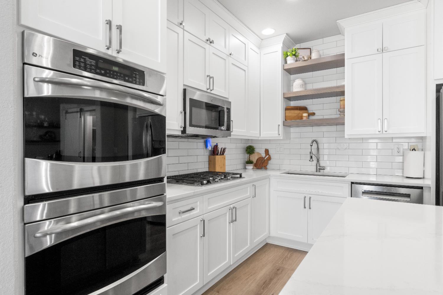 11749 Dionysus Way Rancho Cordova, CA 95742 - Photo 17 of 56 a kitchen with stainless steel appliances white cabinets and stove