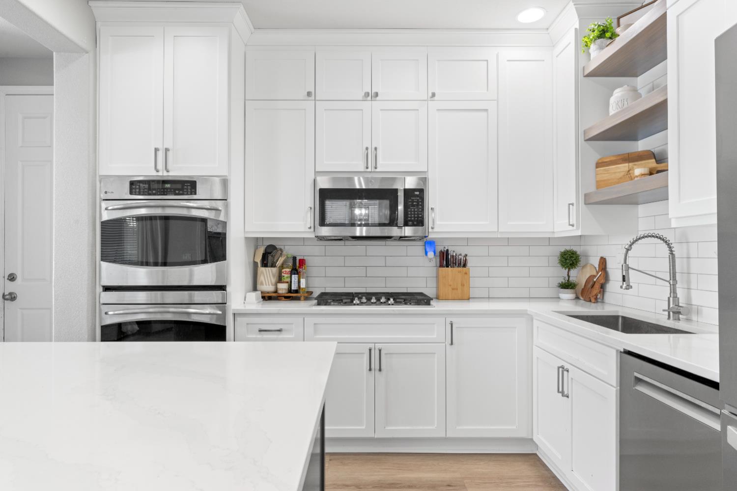 11749 Dionysus Way Rancho Cordova, CA 95742 - Photo 18 of 56 a kitchen with granite countertop white cabinets and stainless steel appliances