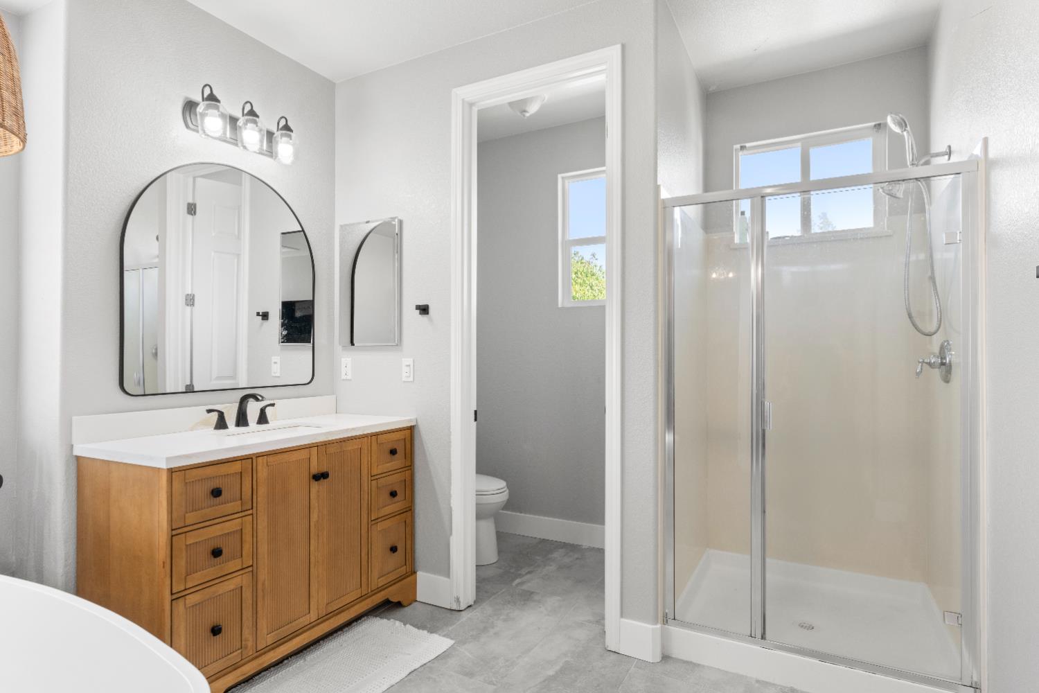 11749 Dionysus Way Rancho Cordova, CA 95742 - Photo 31 of 56 a spacious bathroom with a double vanity sink a toilet a mirror and shower
