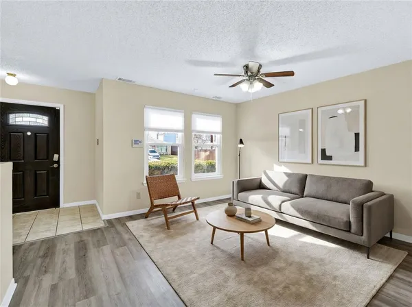 a living room with furniture a ceiling fan and a rug