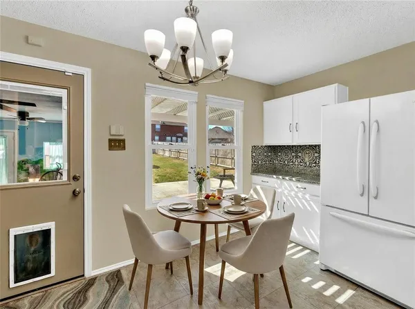a view of a dining room with furniture a chandelier and wooden floor