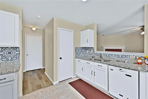 a bathroom with a granite countertop sink two mirror and a shower