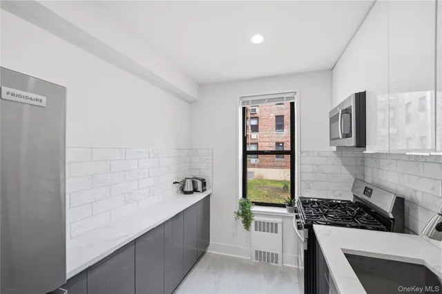 a kitchen that has a sink stainless steel appliances and cabinets