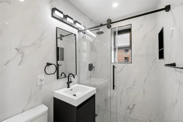 a bathroom with a sink a toilet and shower