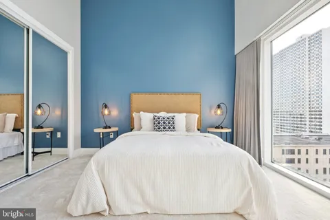 a bedroom with a bed and a large window