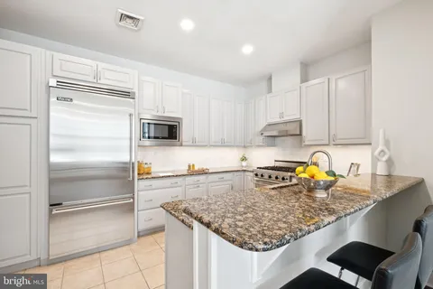 a kitchen with stainless steel appliances granite countertop a sink refrigerator and microwave