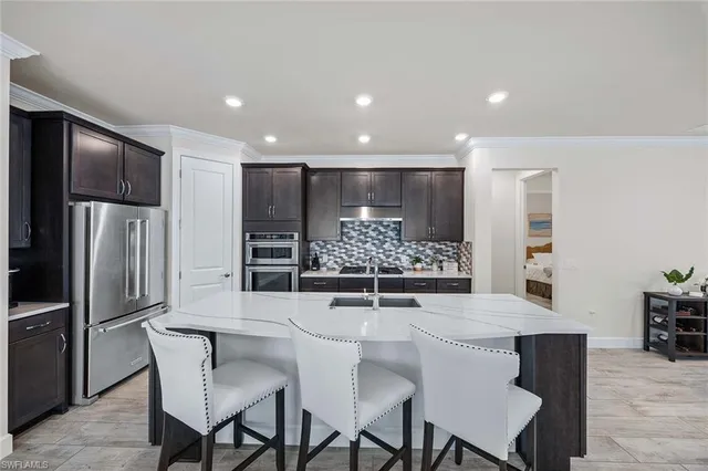 a kitchen with stainless steel appliances kitchen island granite countertop a table and chairs