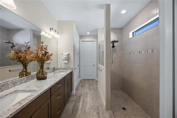 a bathroom with a granite countertop sink a mirror and a shower