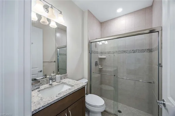 a bathroom with a granite countertop sink toilet and shower
