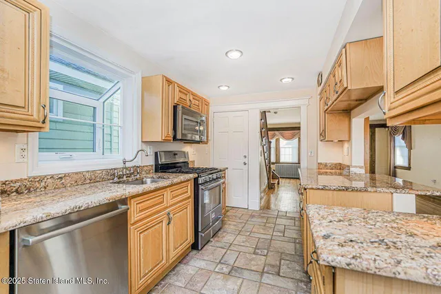 a kitchen with granite countertop a sink stove and cabinets