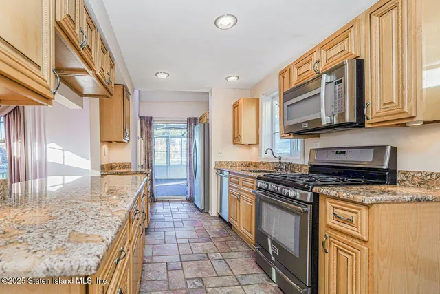 a kitchen with stainless steel appliances granite countertop a stove a sink and a granite counter tops