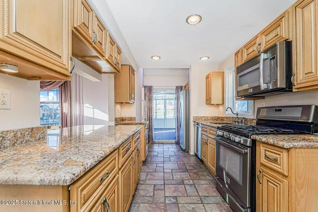 a kitchen with stainless steel appliances granite countertop a sink stove and refrigerator