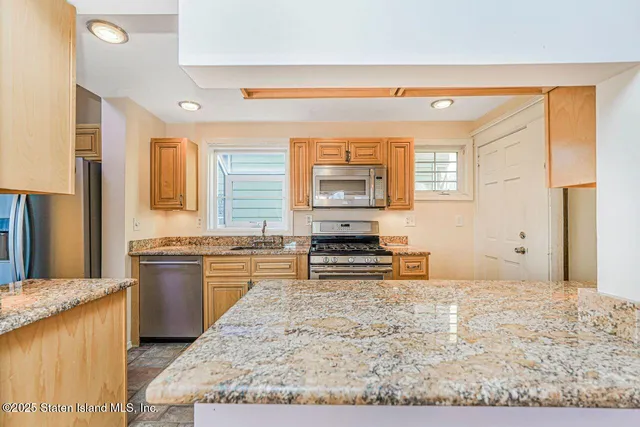 a kitchen with stainless steel appliances granite countertop a sink stove and cabinets