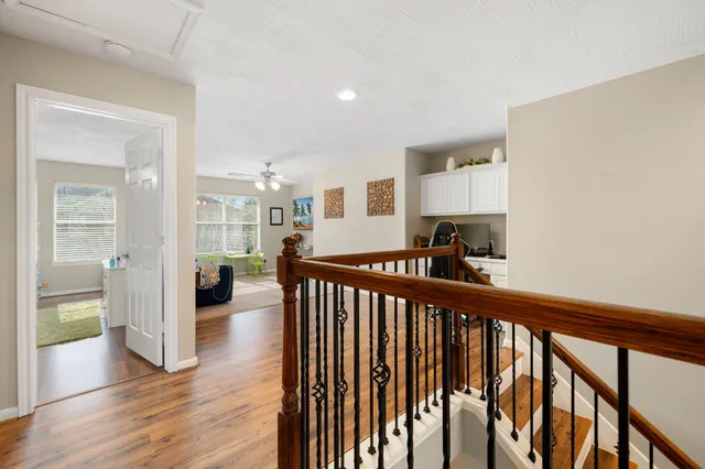 a view of a hallway with wooden floor and a living room