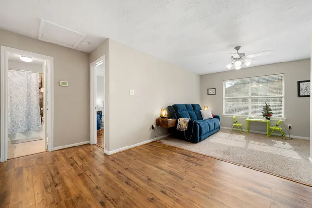 a living room with furniture and a wooden floor