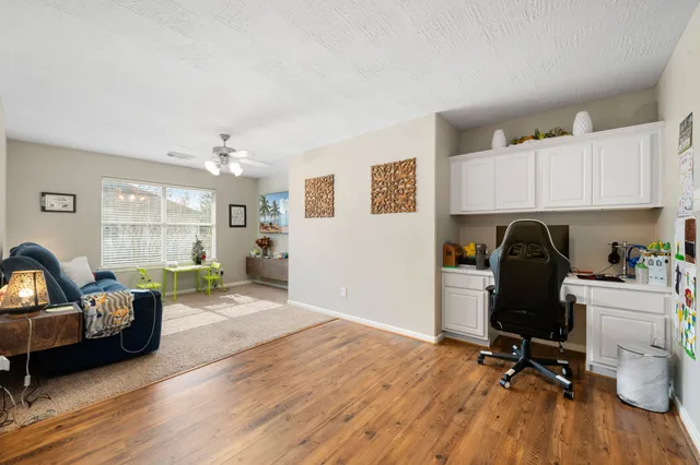 a view of a workspace with furniture and wooden floor