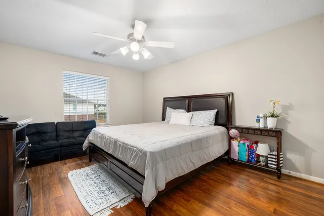 a bedroom with a bed wooden floor and window