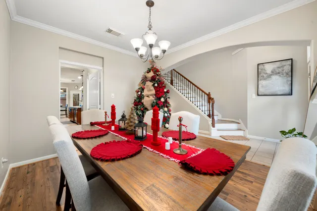 a view of a dining room with furniture a chandelier and wooden floor