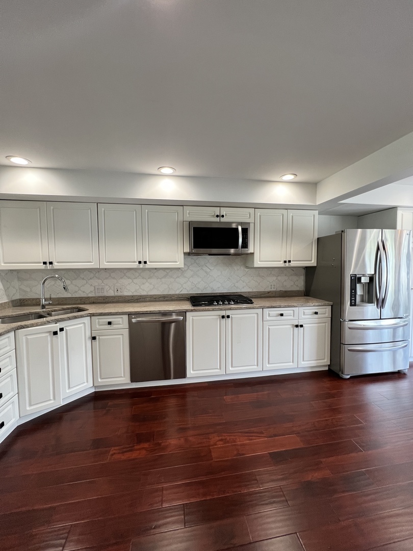 2535 Techny Road Northbrook, IL 60062 - Photo 5 of 30 a large kitchen with granite countertop a stove a sink dishwasher and a oven with white cabinets
