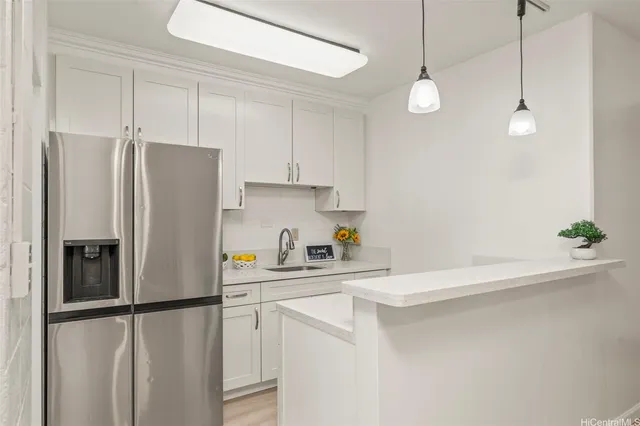 a kitchen with stainless steel appliances a refrigerator sink and white cabinets