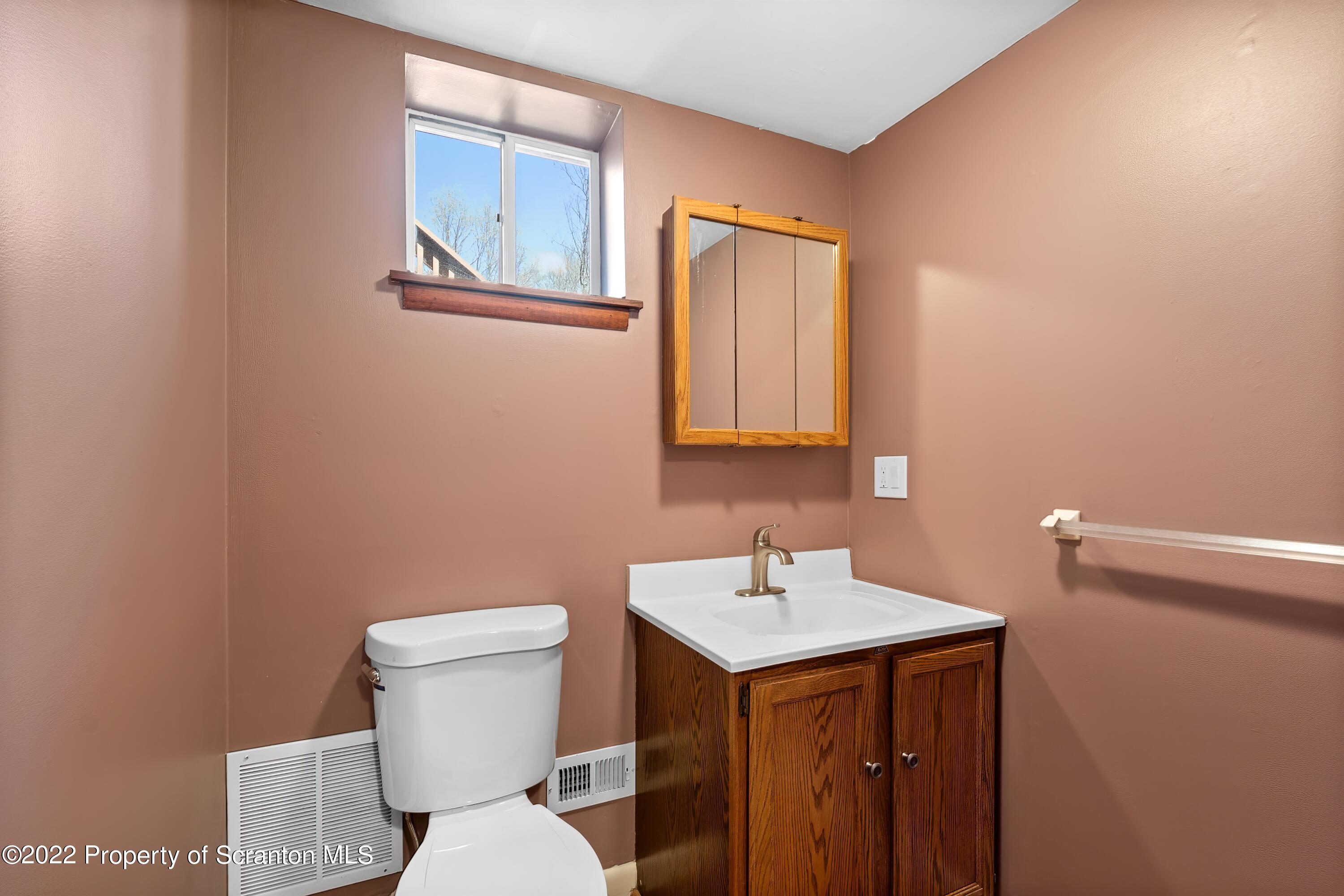 219 Noble Road Clarks Summit, PA 18411 - Photo 29 of 33 a bathroom with a toilet a sink and mirror