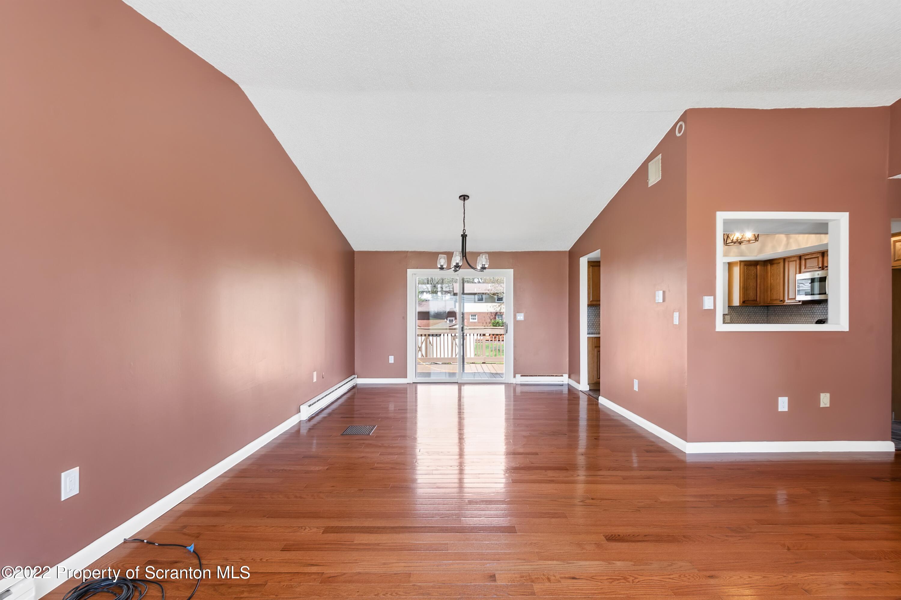 219 Noble Road Clarks Summit, PA 18411 - Photo 3 of 33 a view of an empty room with chandelier and wooden floor
