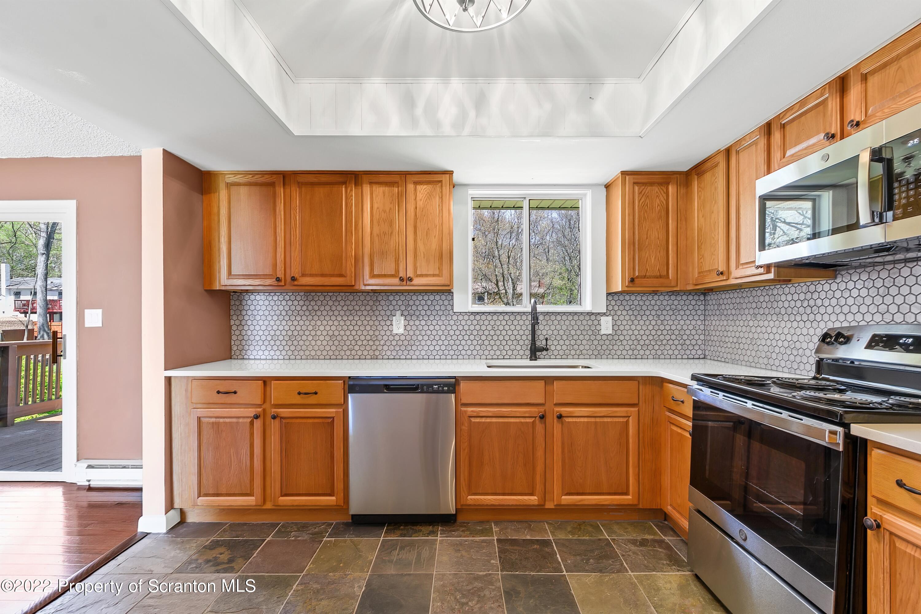 219 Noble Road Clarks Summit, PA 18411 - Photo 7 of 33 a kitchen with stainless steel appliances granite countertop a sink stove and cabinets