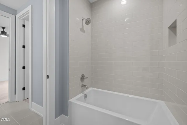a white bath tub sitting next to a shower