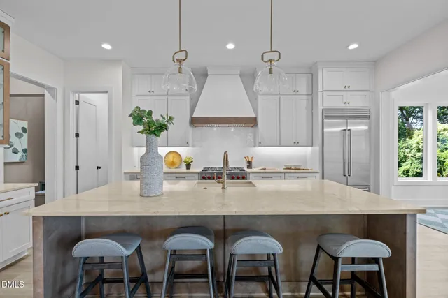 a kitchen with granite countertop a wooden floor and white cabinets