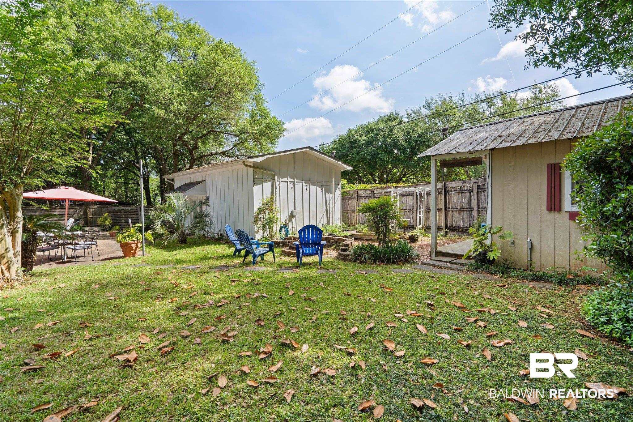 559 East Cumberland Road Mobile, AL 36608 - Photo 37 of 48 Fenced backyard with a patio area, a storage shed, and an outdoor fire pit
