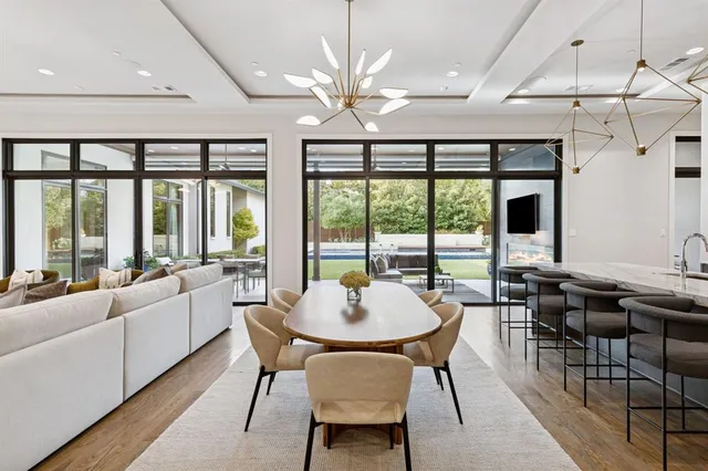 a dining room with furniture a chandelier and large windows