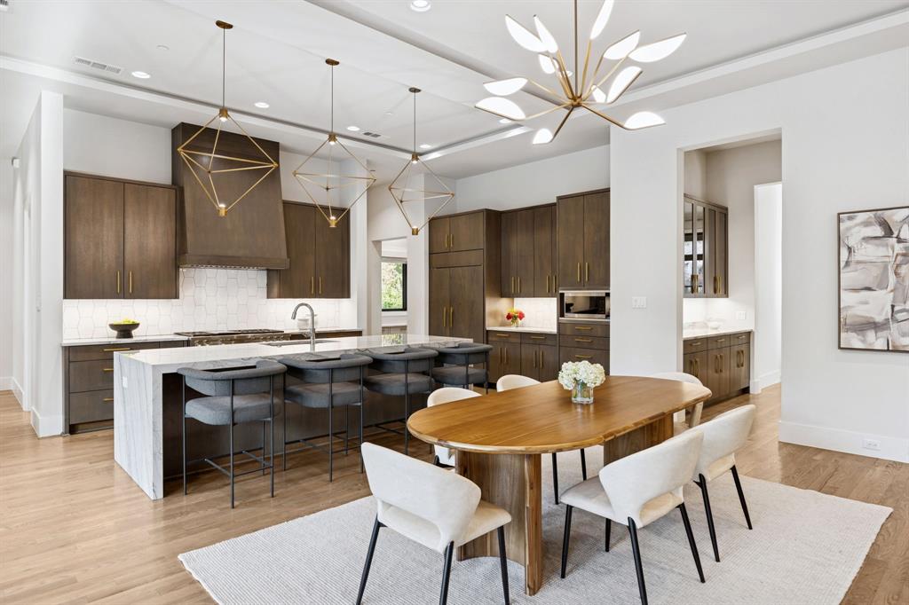 4447 Taos Road Dallas, TX 75209 - Photo 13 of 40 a kitchen with stainless steel appliances granite countertop a sink a stove a dining table and chairs