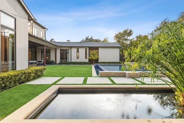 a view of backyard with large trees and plants