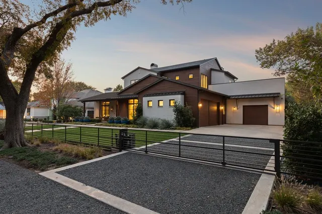 a view of a house with a yard and a large tree