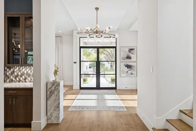 a view of a hallway with windows and chandelier