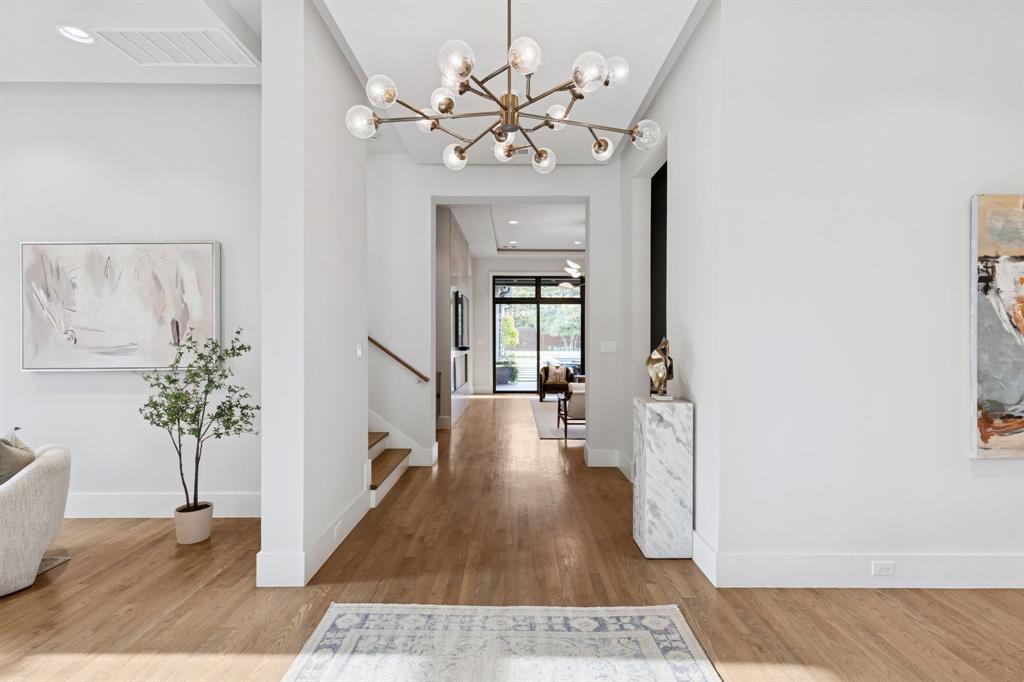 4447 Taos Road Dallas, TX 75209 - Photo 7 of 40 a view of a hallway with wooden floor and a chandelier