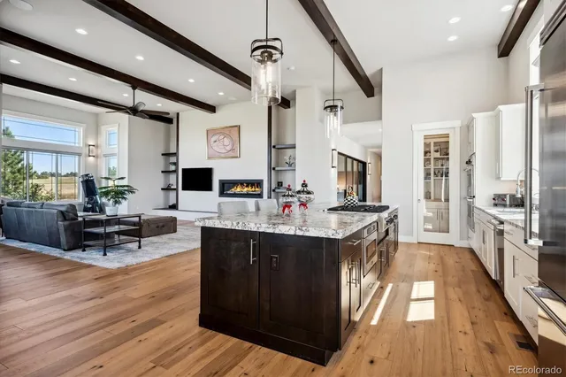 a large living room with stainless steel appliances granite countertop a couch and wooden floors