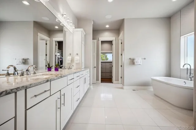 a large bathroom with a sink mirror and a bath tub