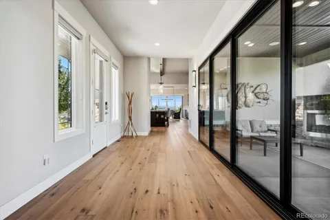 a view of a hallway with wooden floor and a living room