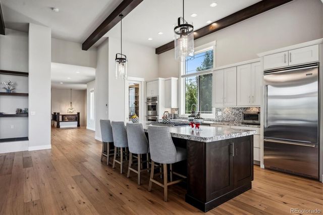 a kitchen with kitchen island granite countertop a sink counter and chairs